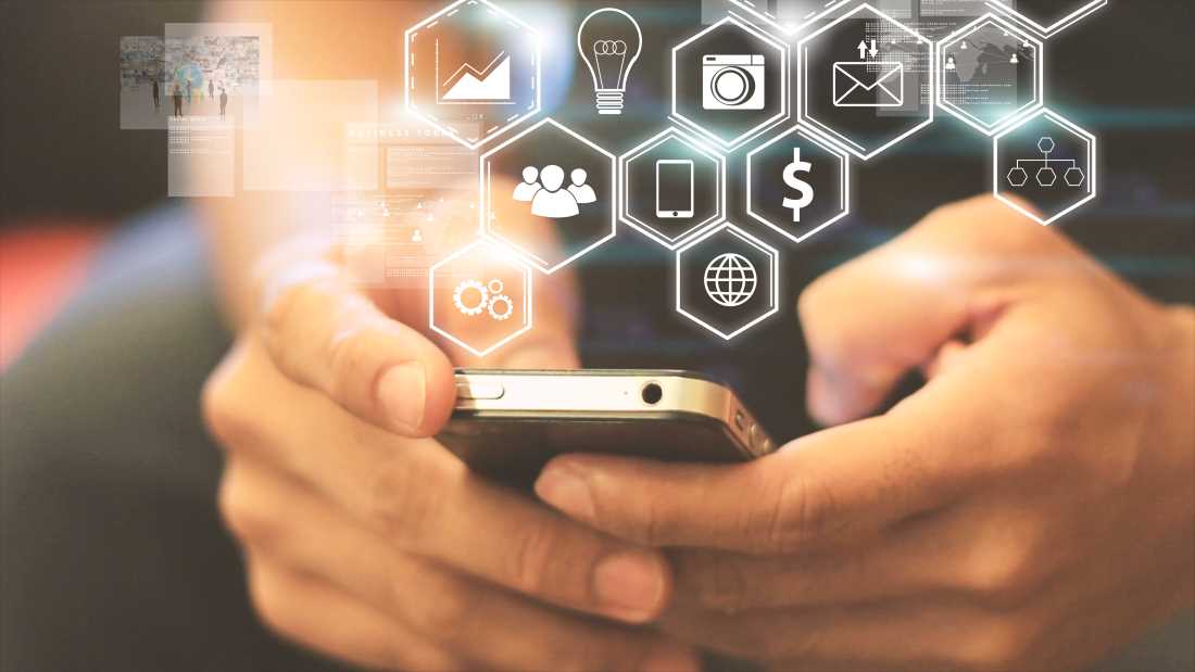 A professional using a smartphone app connected to a business VoIP solution in St. Paul, MN
